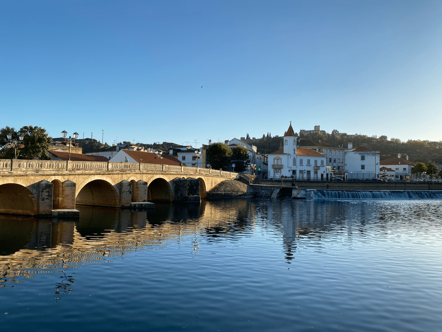 Puente histórico sobre el río Nabão, con vistas al Castillo de Tomar al fondo.